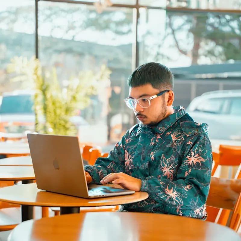 Person working on a laptop in a Polish cafe